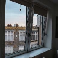 Open window overlooking neighboring brick apartments.